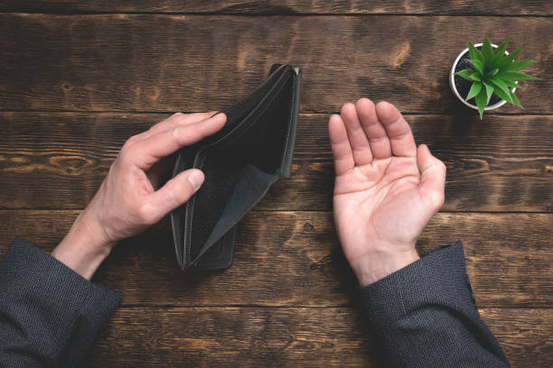 Empty wallet in hands on an office table background.